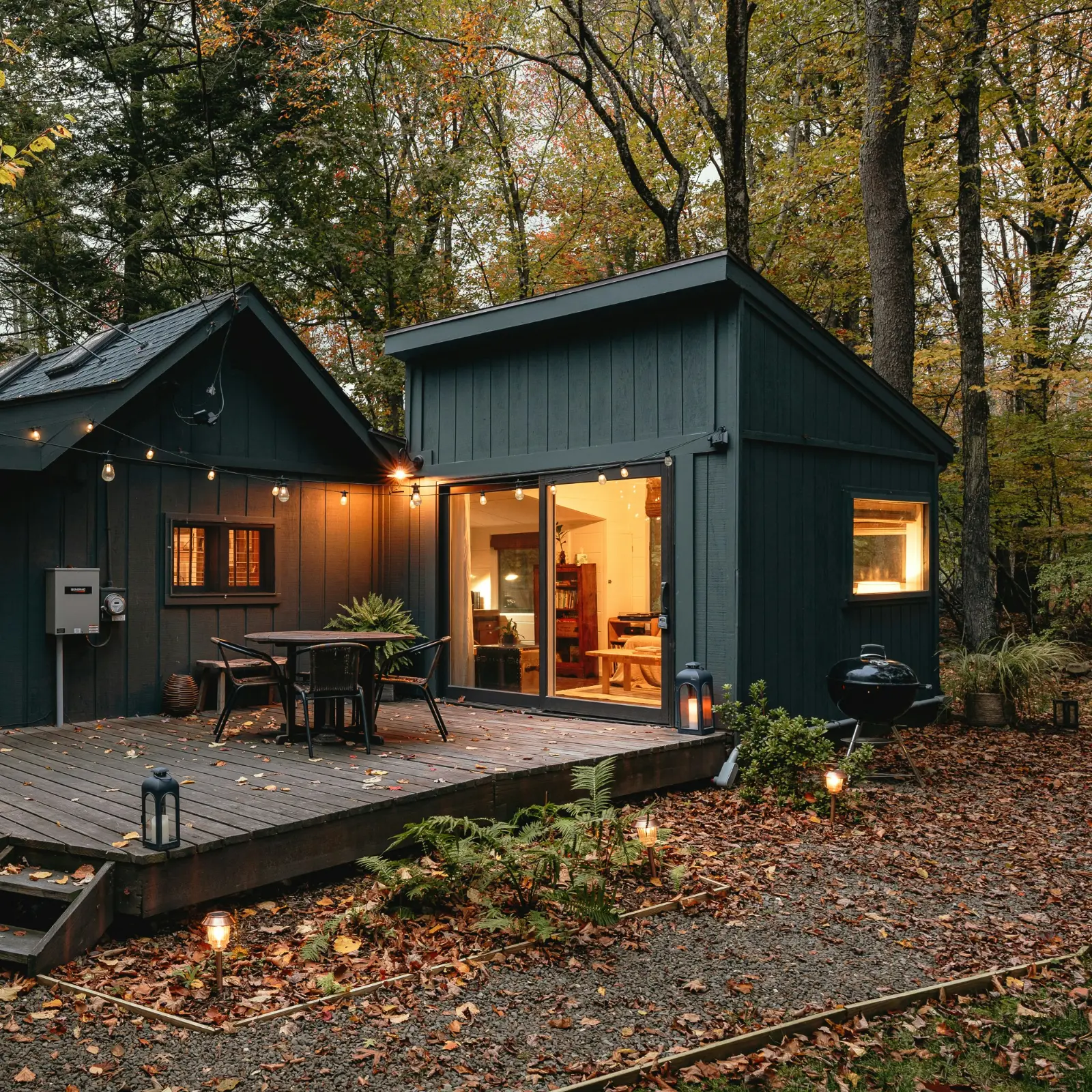 Vardagsrum med stora fönster och möbler i neutrala färger